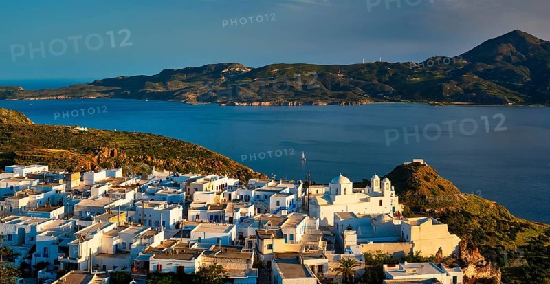 View of Plaka village on Milos island with traditional greek white houses on sunset. Plaka town, Milos island, Greece, Europe