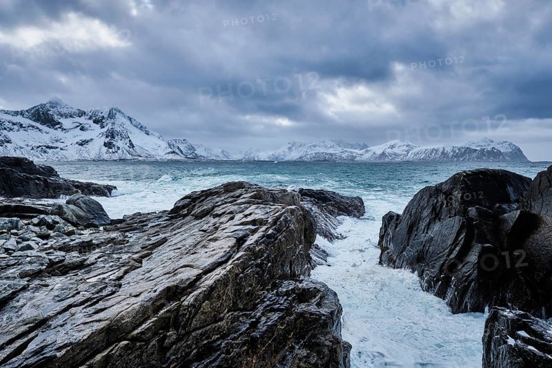 Waves of Norwegian sea crushing at rocky coast in fjord. Vikten, Lofoten islands, Norway, Europe