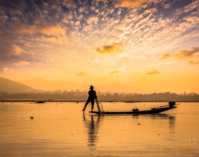 Myanmar travel attraction landmark, traditional Burmese fisherman sihouettes at Inle lake on sunset, Myanmar famous for their distinctive one legged rowing style