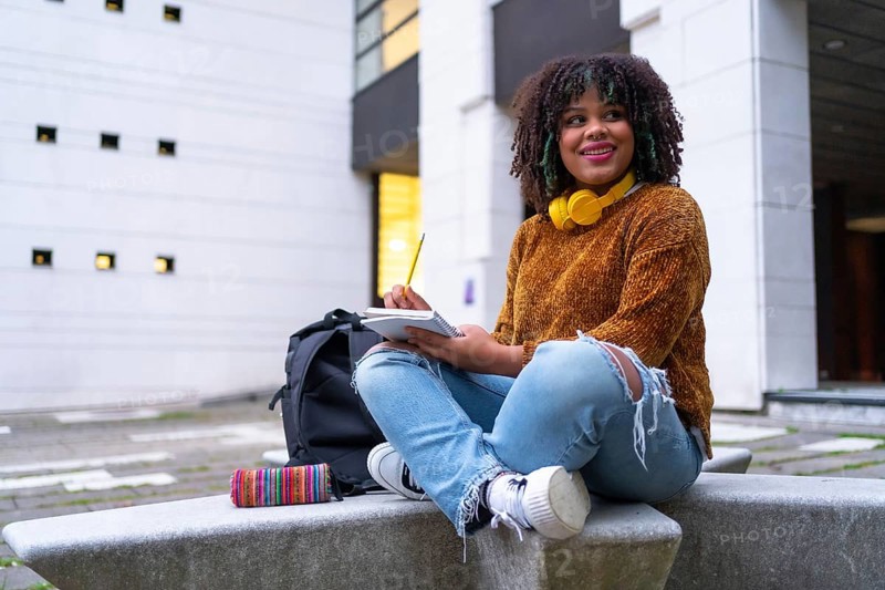 Portrait of black ethnic girl sitting in college doing classwork or studying for an exam