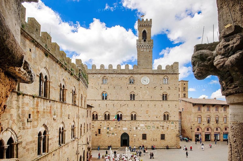 View of historical building from the Middle Ages Palazzo dei Priori town hall of Volterra built in 1208, 13th century, right foreground old symbolic figure on house corner, Volterra, Tuscany, Italy, Europe