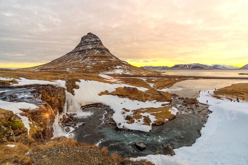 Sunrise on the famous Kirkjufell mountain next to the waterfall in winter in Iceland