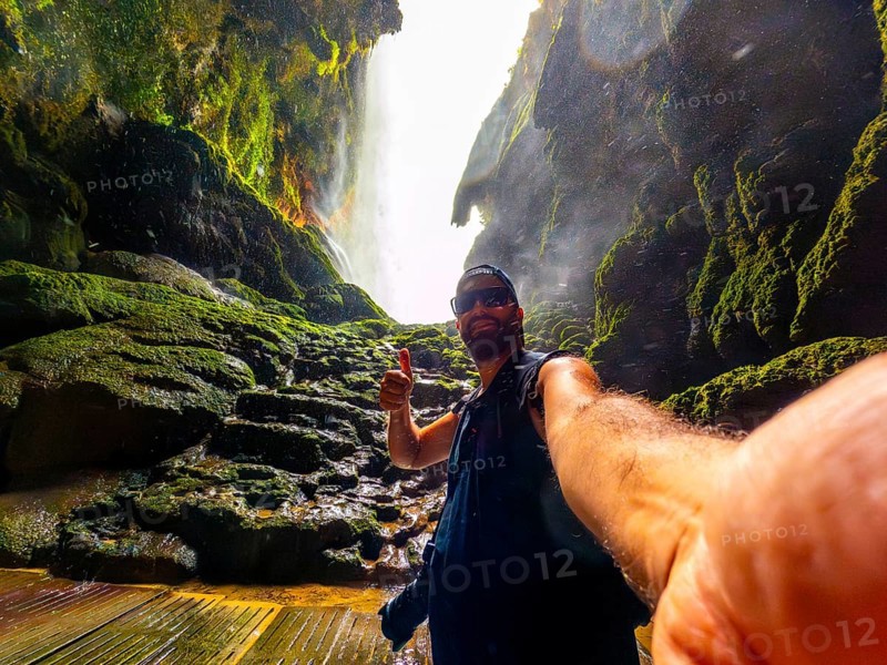 A tourist inside the Iris grotto at the Cola de Caballo Waterfall in the Monasterio de Piedra Natural Park, Aragon