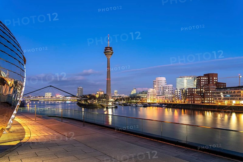 View from the terrace of the Hyatt Hotel of the Gehry buildings - Neuer Zollhof at the Media Harbour and the Rhine Tower in Düsseldorf at dusk, North Rhine-Westphalia, Germany, Europe