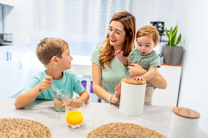 Caucasian family of a single mother with two kids having breakfast before going to school