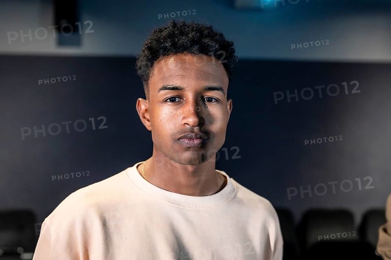 Portrait of a young man standing in a movie theater during a movie session, possibly participating in a movie disco dance or a special event