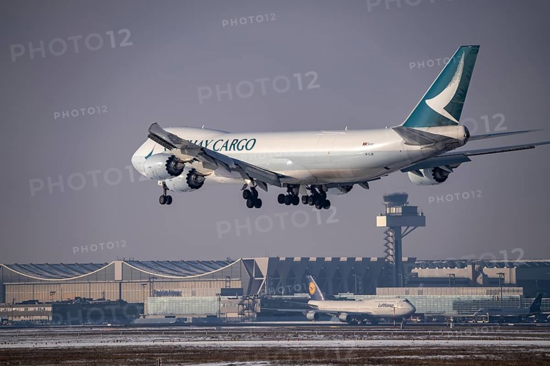 Cathay Pacific Boeing 747-8F cargo aircraft approaching Frankfurt FRA airport, air traffic control tower, Fraport, in winter, Hesse, Germany, Europe