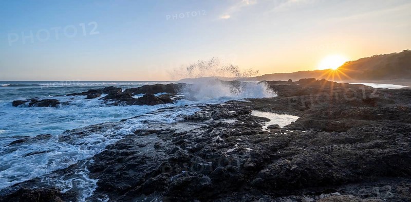 Waves crashing against rocks, Playa Cocalito, coastal landscape at sunset, sun star, Pacific coast, Nicoya Peninsula, Puntarenas province, Costa Rica, Central America