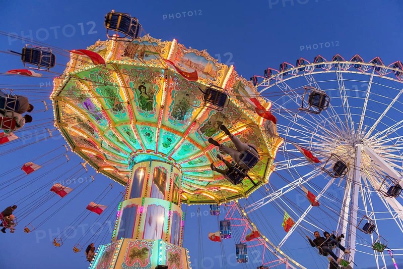 Illuminated carousel and Ferris wheel at night in a lively amusement park, funfair, wave flight, Cannstadter Volksfest, Stuttgart-Bad Cannstsdt, Baden-Württemberg