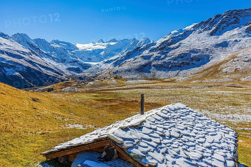 Alpine hut with snow-covered roof, slightly snow-covered alpine meadow, behind the Moiry glacier, near Grimentz, Val d'Anniviers, Valais Alps, Canton Valais, Switzerland, Europe