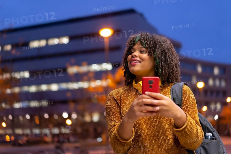 Portrait of black ethnic girl in the early morning going to the university on the way back to school talking on the phone