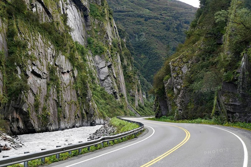 Road leads through a narrow canyon, high cliffs and Chugach Mountains, Thompson Pass, Richardson Highway, Alaska, USA, North America