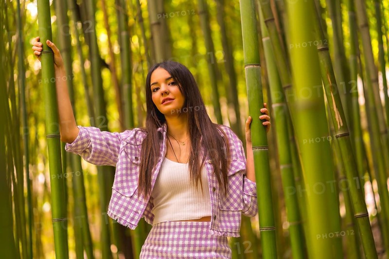 Young caucasian girl with a pink skirt in a bamboo forest. Enjoying the city on summer vacation in a tropical climate, lifestyle of a girl walking through the beautiful forest