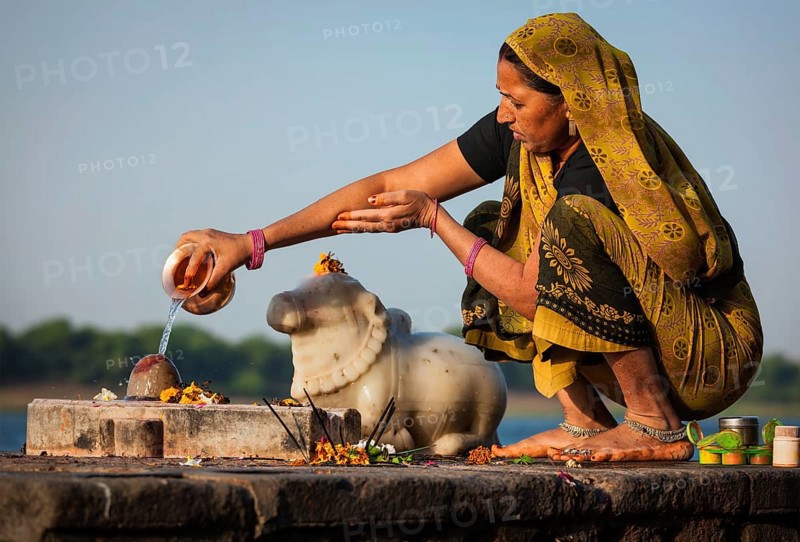 MAHESHWAR, INDIA, APRIL 26: Indian woman performs morning pooja on sacred river Narmada ghats on April 26, 2011 in Maheshwar, Madhya Pradesh, India. To Hindus Narmada is one of 5 holy rivers of India