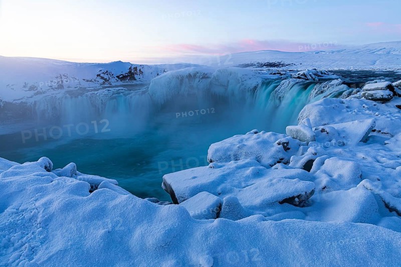 Icefall at the edge of the Godafoss waterfall at dawn, snow-covered landscape, Northern Iceland Eyestra, Iceland, Europe