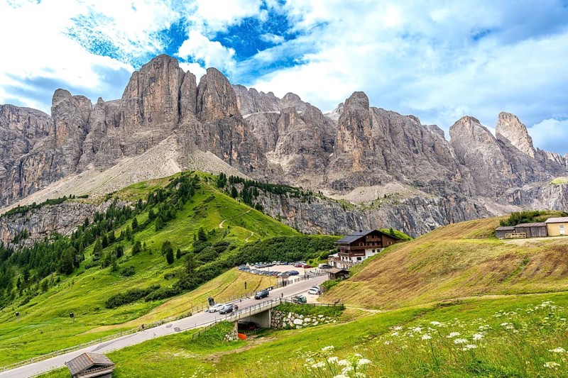 Breathtaking landscape showing the winding road of passo gardena and the majestic mountain range of the dolomites in summer, italy