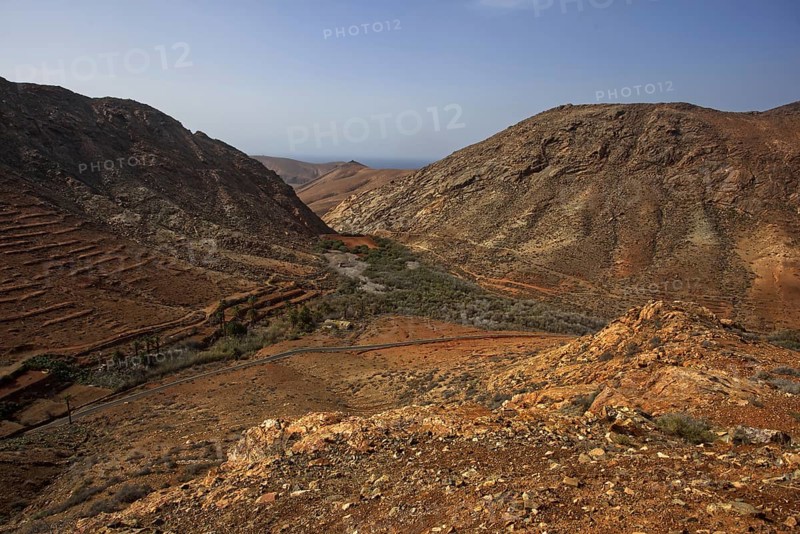Rough, barren valley between steep mountains near the village of Vega de Rio Palmas under sunny skies, Betancuria, Fuerteventura, Canary Islands, Spain, Europe