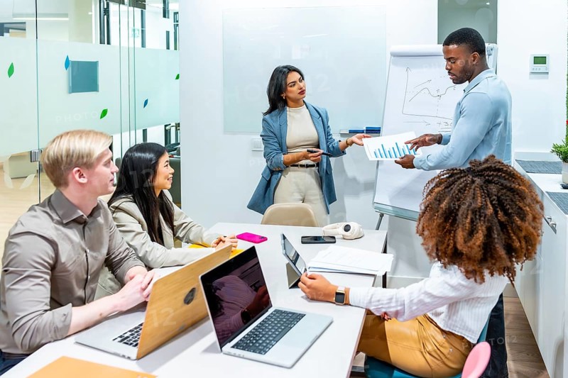 Business professionals collaborating on data analysis, discussing charts and growth strategies during a productive meeting in a contemporary office