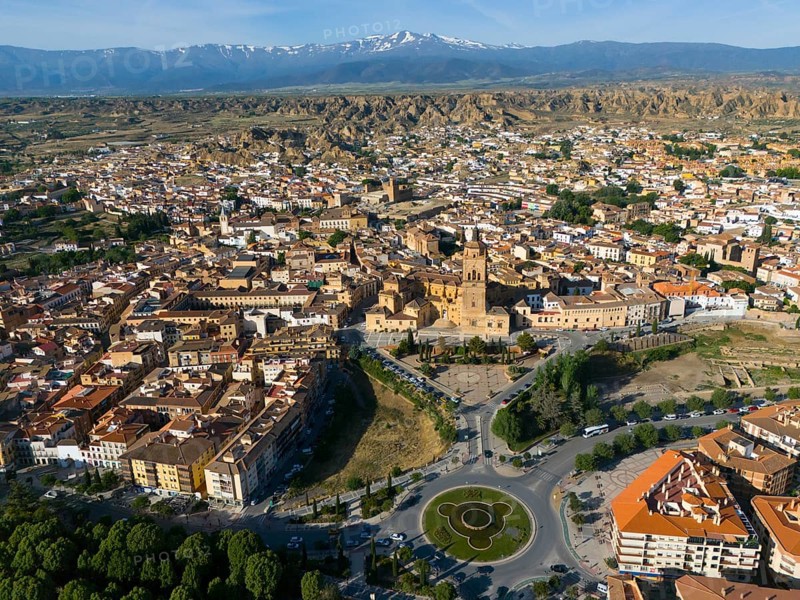 Aerial view of a city with historical centre, roundabout and green parks, surrounded by landscape and mountains in the background, aerial view, Cathedral, Catedral de la Encarnación de Guadix, Guadix, Sierra Nevada, Granada, Andalusia, Spain, Europe