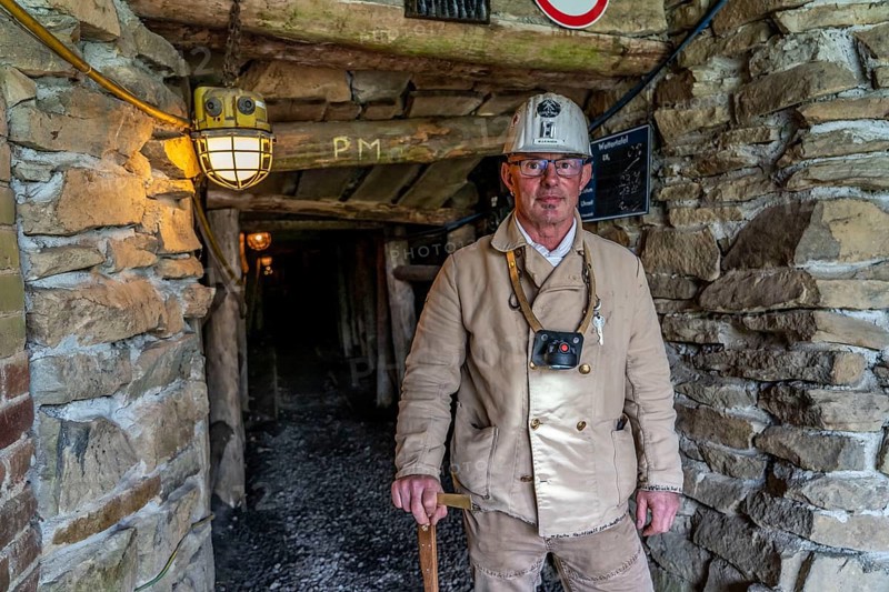 Visitor group at the entrance to the Nachtigallstollen, tour guide, GeoRoute Ruhr, Dünkelberg quarry, in the Muttental valley, here you can see the geology of the region, a thin coal seam is visible, underneath were thicker layers of coal that were mined, Witten, North Rhine-Westphalia, Germany, Europe