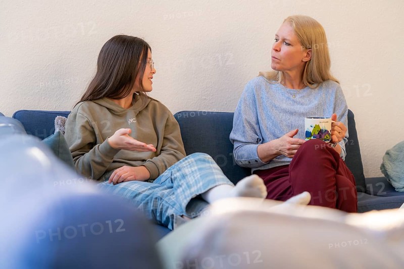 Mother and daughter, teenage, 13 years old, in a confidential conversation, at home