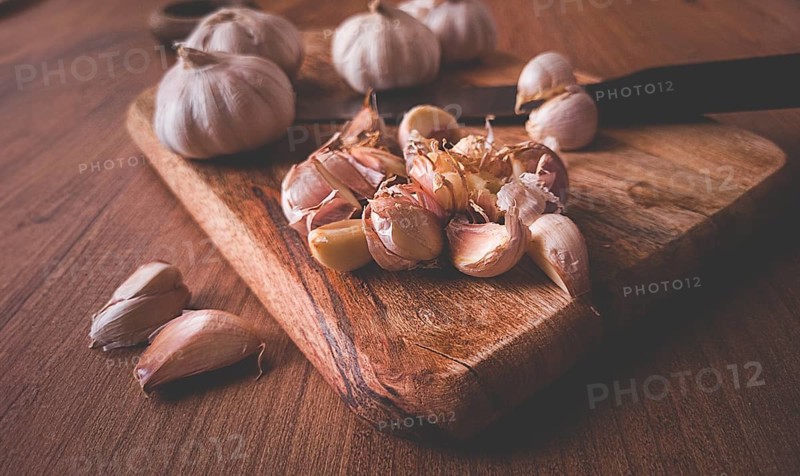 Fresh garlic on a chopping board, wooden table, knife, rustic, mobile photo, no people