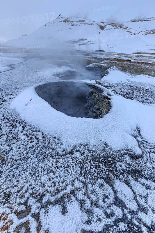 Hot springs and geothermal area in front of a mountain landscape in winter, cloudy mood, Hverir, Namafjall, Myvatn, Iceland, Europe