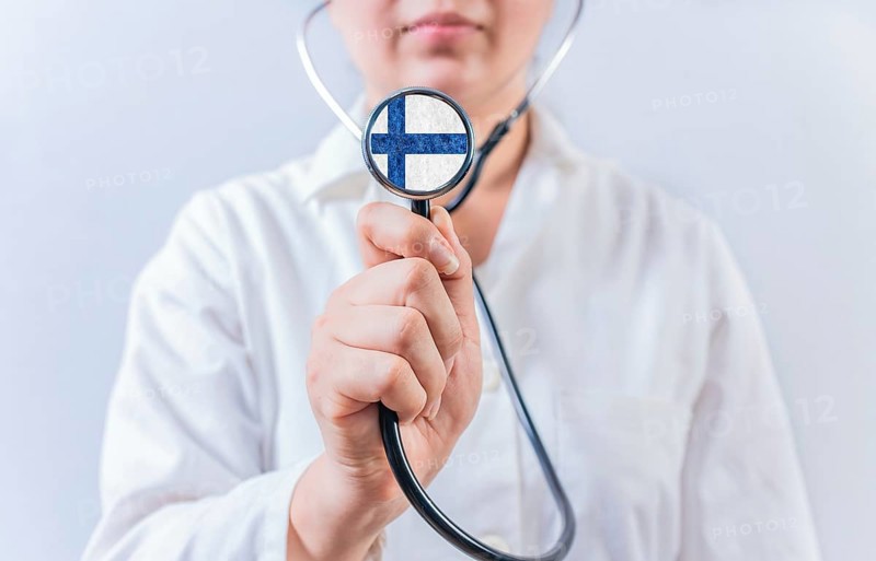 Female doctor holding stethoscope with Finland flag. Finland Health and Care Concept