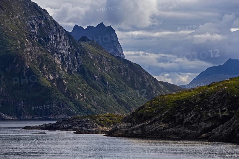 Dramatic coastline with green slopes and clouds over Bergen, Norway, Europe