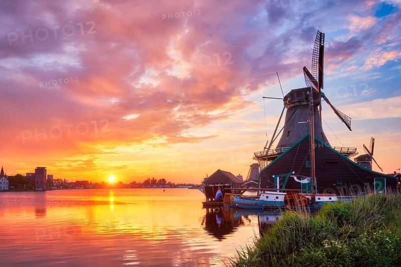 Netherlands rural scene, - windmills at famous tourist site Zaanse Schans in Holland on sunset with dramatic sky. Zaandam, Netherlands