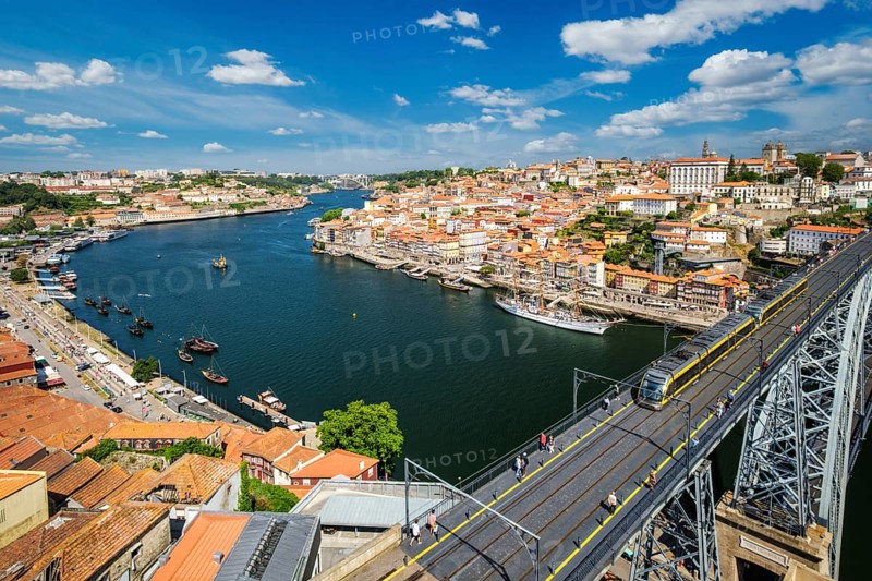 View of Porto city and Douro river with moored sailing ship and Dom Luis bridge I from famous tourist viewpoint Miradouro da Serra do Pilar on sunset. Porto, Vila Nova de Gaia, Portugal, Europe
