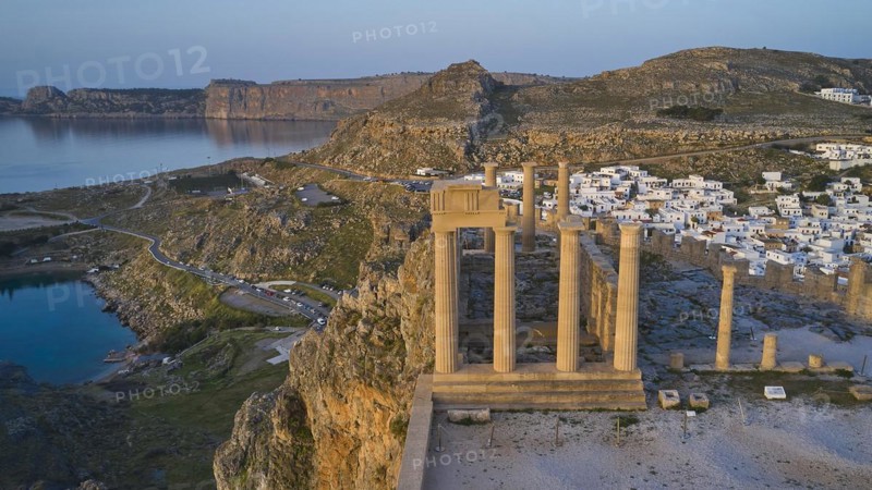 Drone shot, first morning light, Lindos, Acropolis of Lindos, Temple of Athena Lindia, Acropolis with ancient columns in front of a sunlit sea and sky, Archaeological site, Lindos, Rhodes, Dodecanese, Greek Islands, Greece, Europe