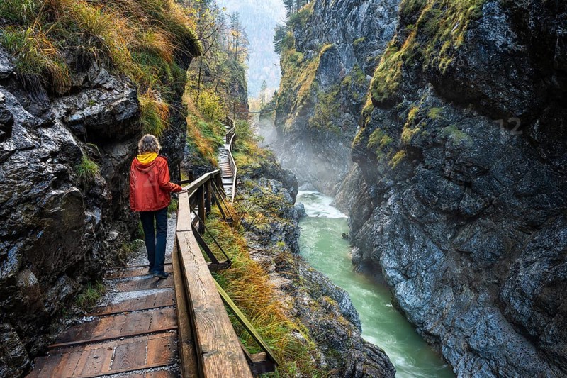 The River Lammer in the Lammerklamm gorge. A hiker on her way through the gorge. Autumn. Scheffau, Lammertal, Salzburger Land, Upper Austria, Austria, Europe