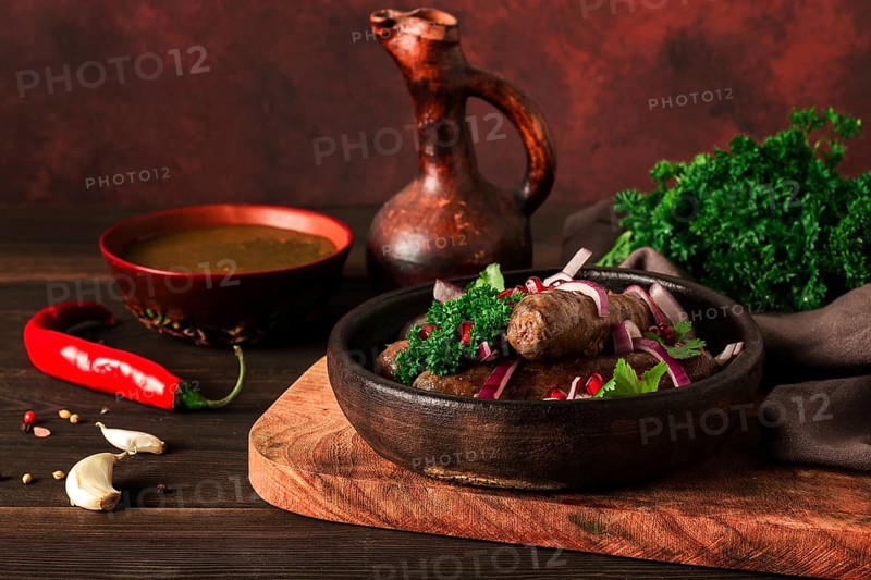 Georgian dish, fried Kupaty sausages, Ketsi on a traditional clay pan, horizontal, no people, selective focus, toned