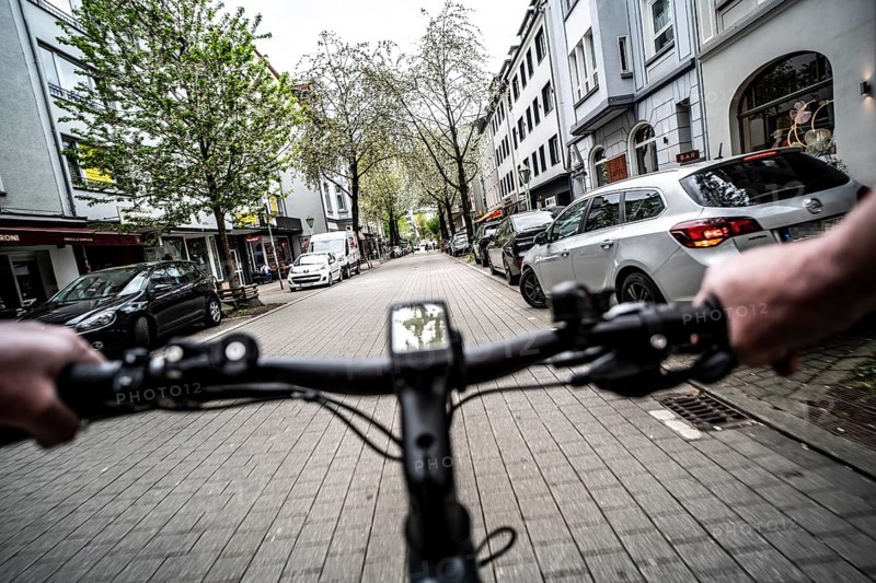Cycling in the city, inner-city street, cycle lane, bicycles have priority, two-lane traffic with parked cars on both sides, cyclists' perspective, Essen, North Rhine-Westphalia, Germany, Europe