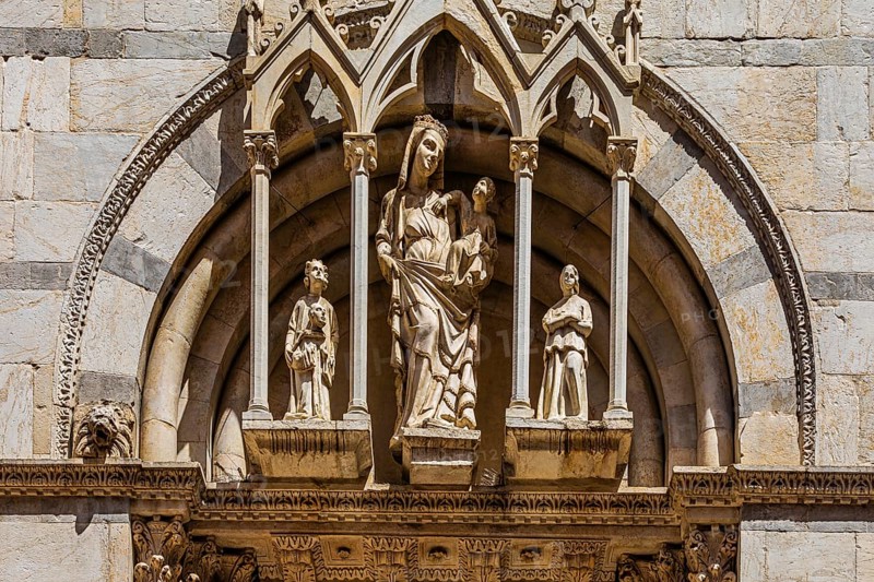 Statue of Mary with the Infant Jesus in the façade of the church of San Michele in Borgo, Pisa, Tuscany, Italy, Europe