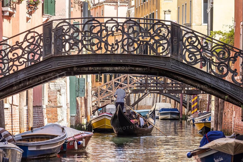 Venetian gondola with gondolier travelling on the canals of Venice, Venice, Italy, Europe