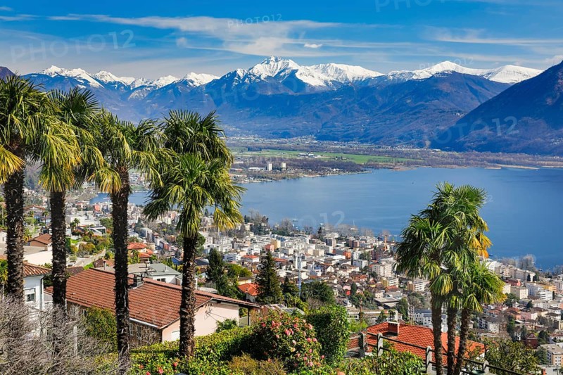 View over the city of Locarno and Lake Maggiore with snow-capped mountains in the background, Canton Ticino, Switzerland, Europe