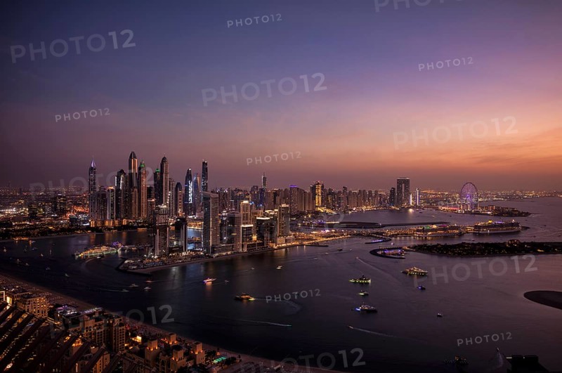 Night shot, view from The View At the Palm viewing platform of skyline with Princess Tower, Elite Residence, Ain Dubai Ferris wheel, luxury yacht OPERA owned by Sheikh Mansour bin Zayed Al Nahyan from the ruling family of the Emirate of Dubai, anchored in front of EMAAR Beachfront, logo, DAMAC, evening mood, Dubai Marina, Dubai, United Arab Emirates, VAR, Asia