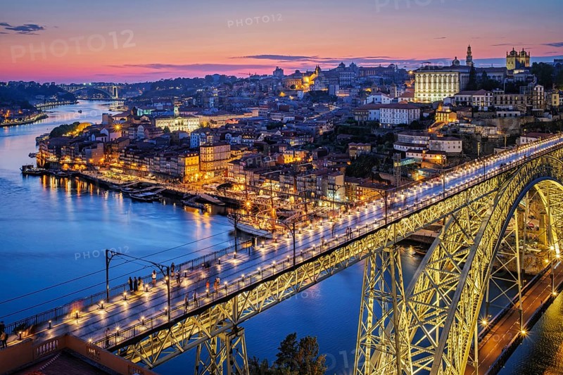 View of illuminated Porto city and Douro river and Dom Luis bridge I from famous tourist viewpoint Miradouro da Serra do Pilar in evening twilight. Porto, Vila Nova de Gaia, Portugal, Europe
