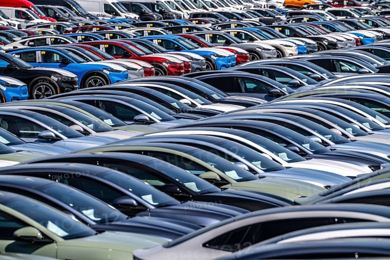 Storage area for new cars in the port of Vlissingen-Oost, vehicles are temporarily stored on over 100 hectares to ship them from Europe to the United Kingdom, Ford cars, others such as models from the Chinese car manufacturer BYD are delivered from here in Europe, wind farm, Netherlands