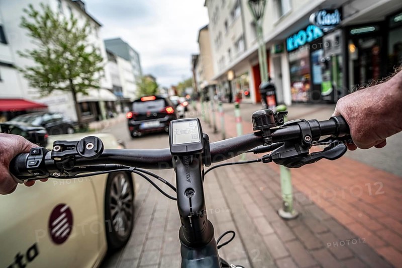 Cycling in the city, inner-city street, cycle lane, bicycles have priority, two-lane traffic with parked cars on both sides, cyclists' perspective, Essen, North Rhine-Westphalia, Germany, Europe