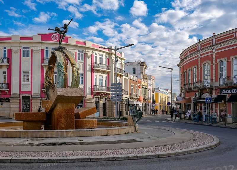Loule, Algarve, Portugal - Houses with colourful facades in the old town of Loulé, roundabout with fountain in the town centre