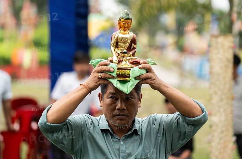 NAMSAI, INDIA.- APRIL 16: A devotees carries the idol of Lord Buddha as he celebrate the vibrant Sangken Festival at Golden Pagoda in Namsai, India on 16 April 2025. Sangken Festival is a beautiful and culturally rich water festival celebrated primarily by the Theravada Buddhist communities, it marks the Buddhist New Year, typically falling in mid-April