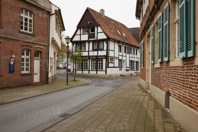 Historic brick houses with white windows and shutters and a small half-timbered house in Warendorf, Warendorf district, North Rhine-Westphalia, Germany, Europe