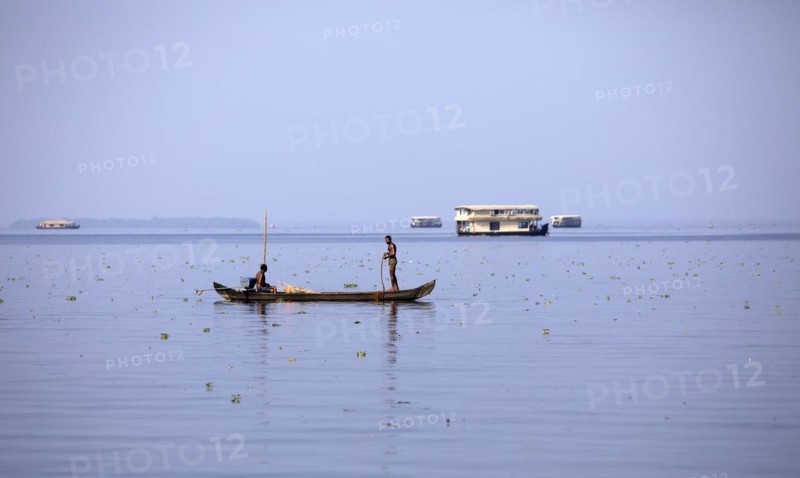 Fisherman on a small boat on the Vembanad Lake, canal system of the backwaters, Kerala, India, Asia