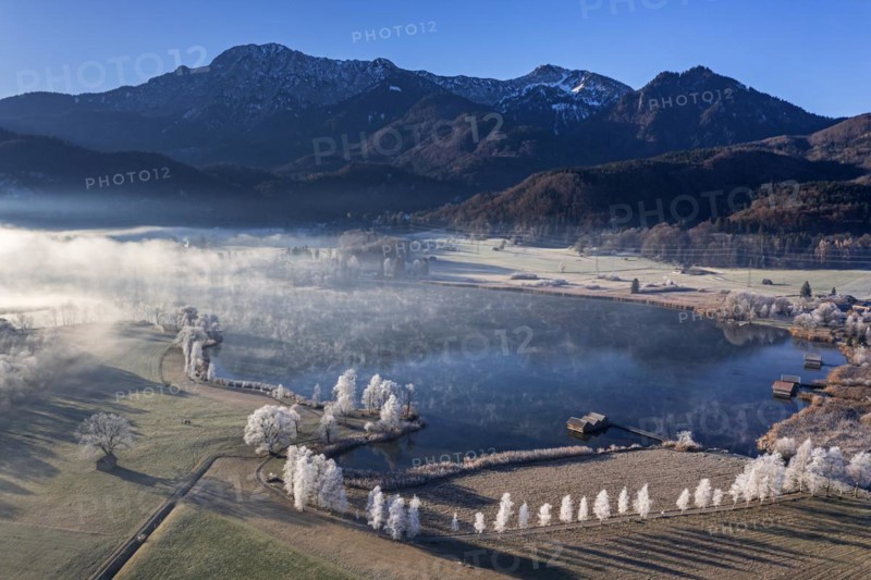 Aerial view of a lake in front of mountains in winter, hoarfrost, morning light, view of Herzogstand and Heimgarten, Lake Kochel, foothills of the Alps, Bavaria, Germany, Europe