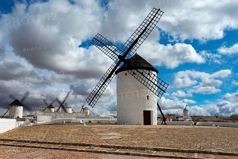 Row of white windmills on a sandy ground with a cloudy sky, Campo de Criptana, Ciudad Real province, Castilla-La Mancha, Route of Don Quixote, Spain, Europe