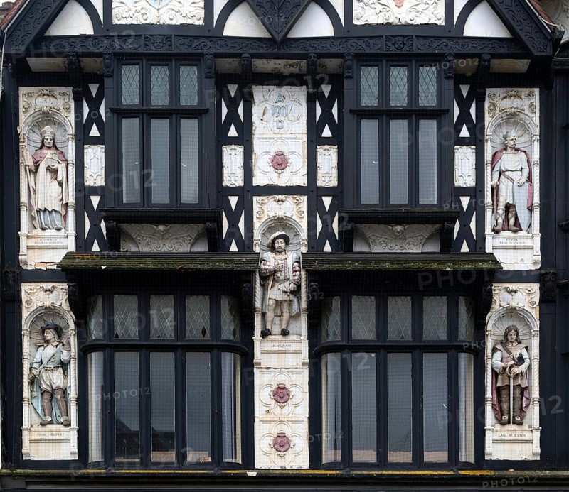 Half-timbered upper elevation painted statues, Peterborough, Cambridgeshire, England, UK designed as a Boots shop architect Michael Vyne Treleaven 1911