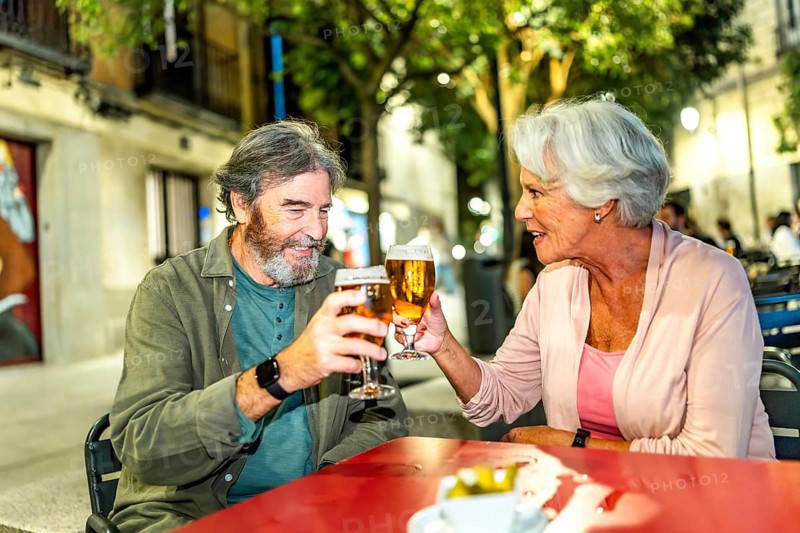 Senior couple toasting in a sidewalk bar in the city of Madrid
